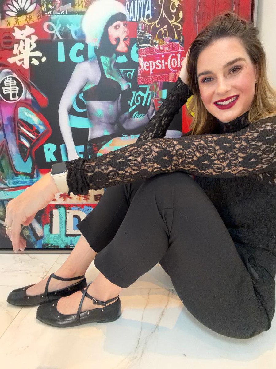 Aline sentada com look preto e sapatilhas Domidona