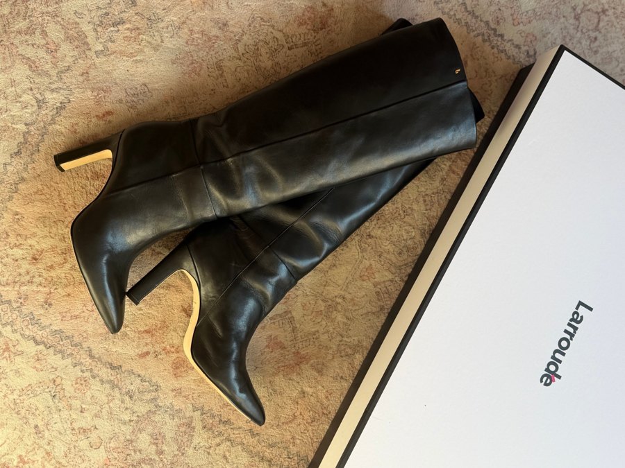 Botas pretas Larroudé ao lado da caixa da marca